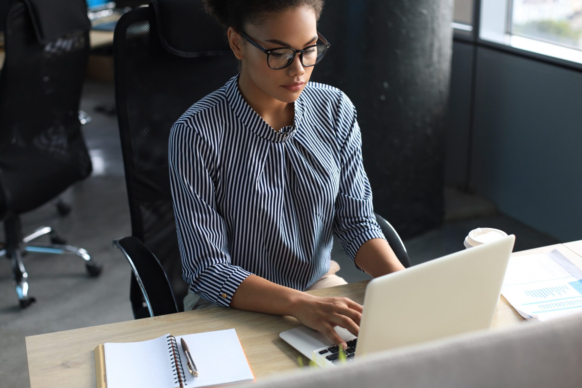 Portrait of beautiful young african american woman working with laptop while sitting at the table Portrait of beautiful young african american woman working with laptop while sitting at the table
