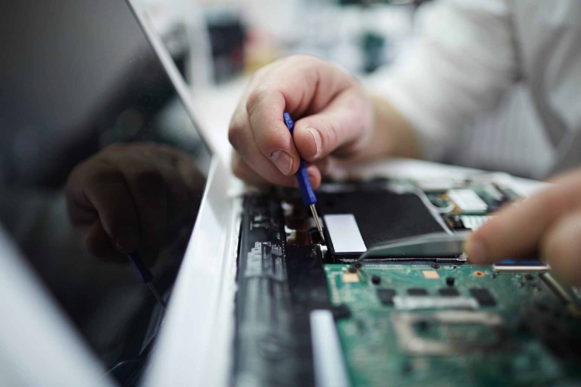 Man Fixing Components in Disassembled Laptop Man Fixing Components in Disassembled Laptop